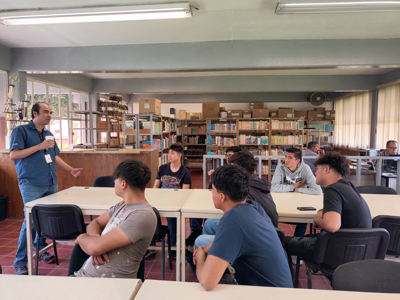 a person standing in front of a group of people sitting at tables