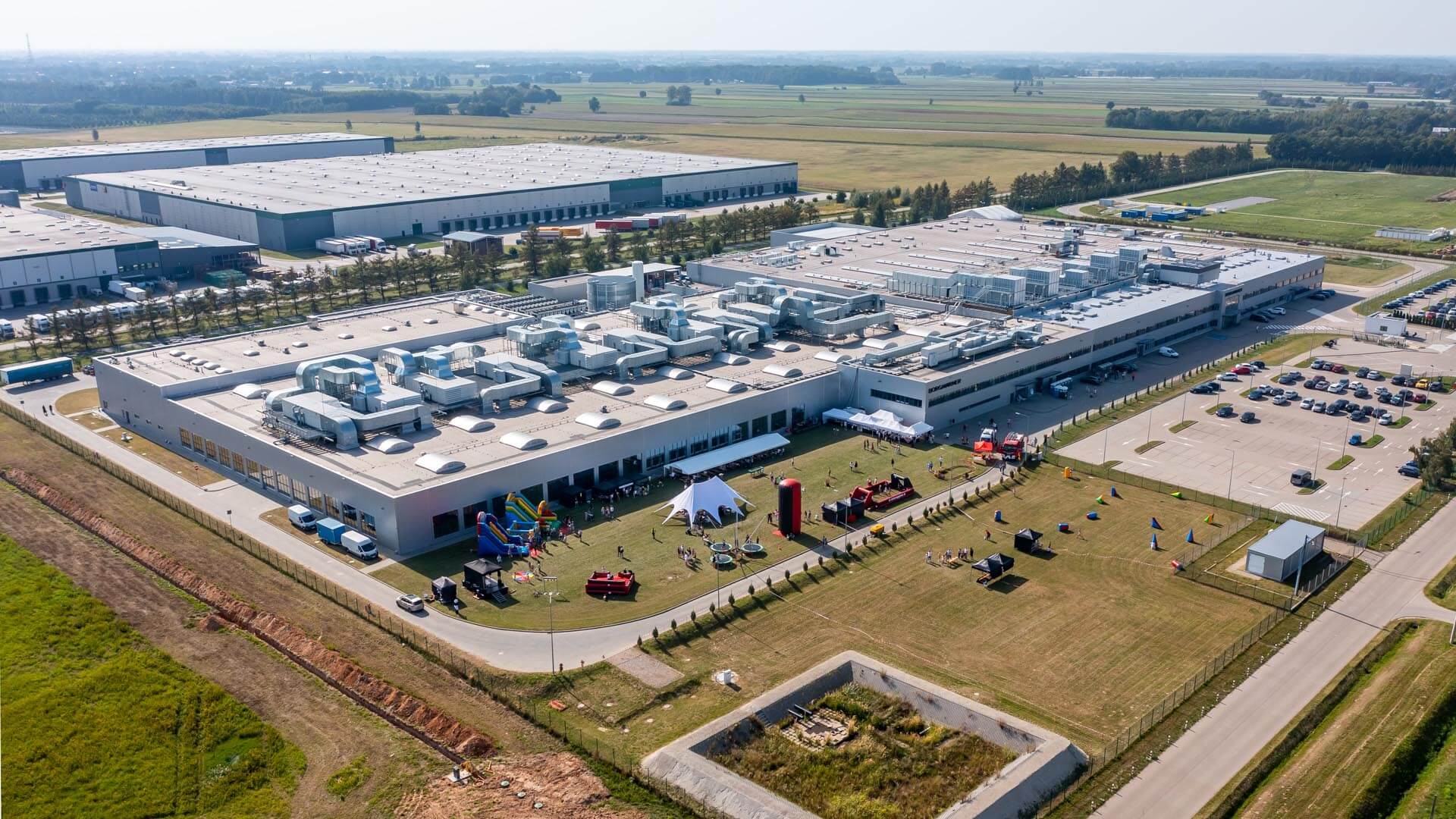 aerial view of a large building with a lot of tents and a parking lot